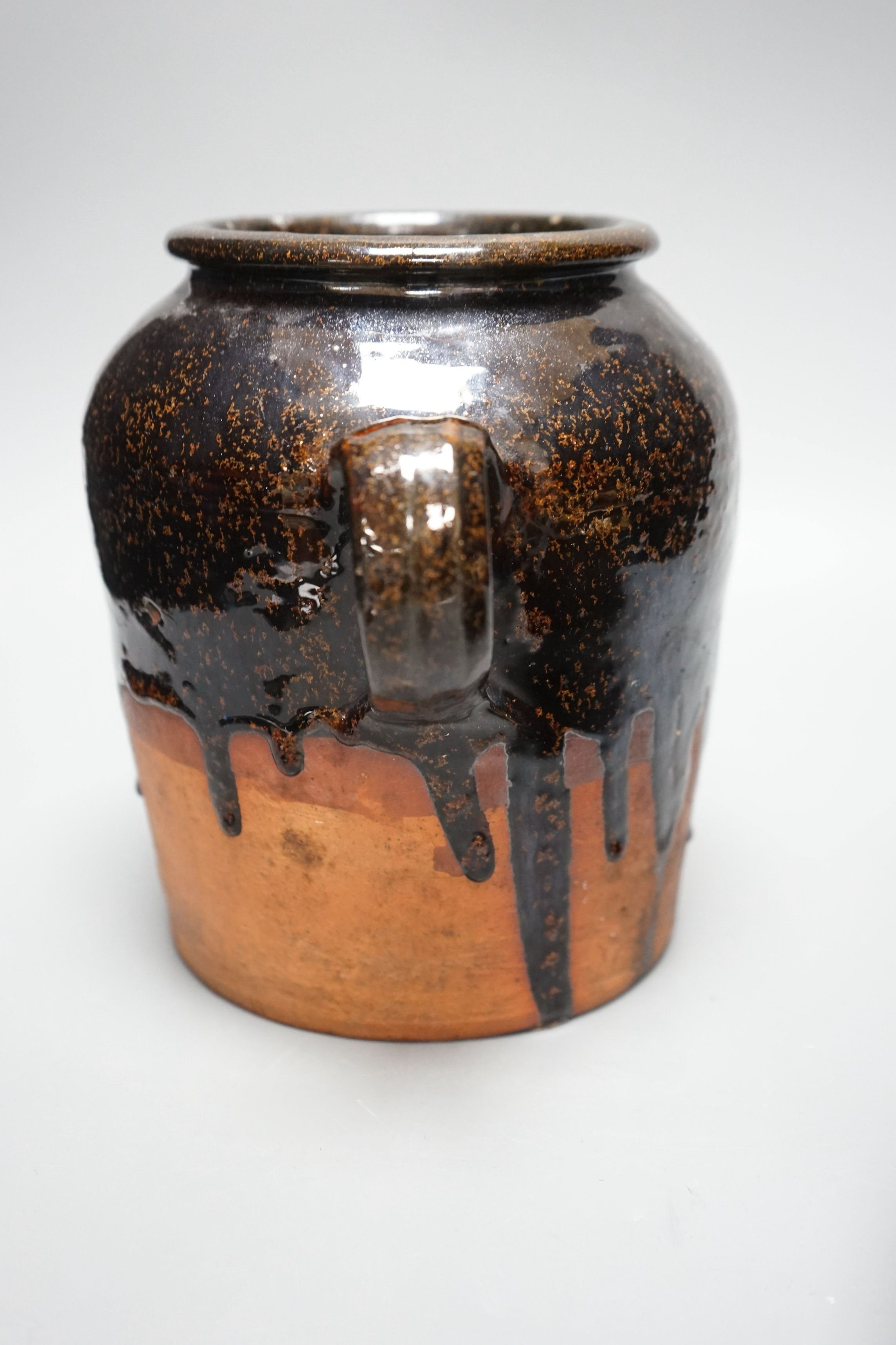 A 19th century slipware bowl and brown glazed single handled storage jar, 21cm tall, (2)